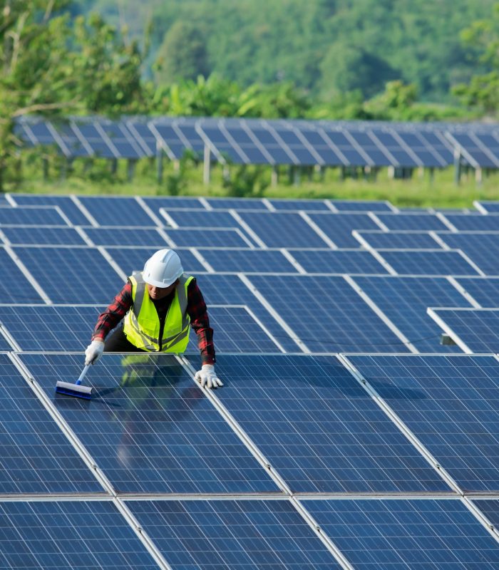 Cleaning solar panels by workers in uniform safety at solar farm