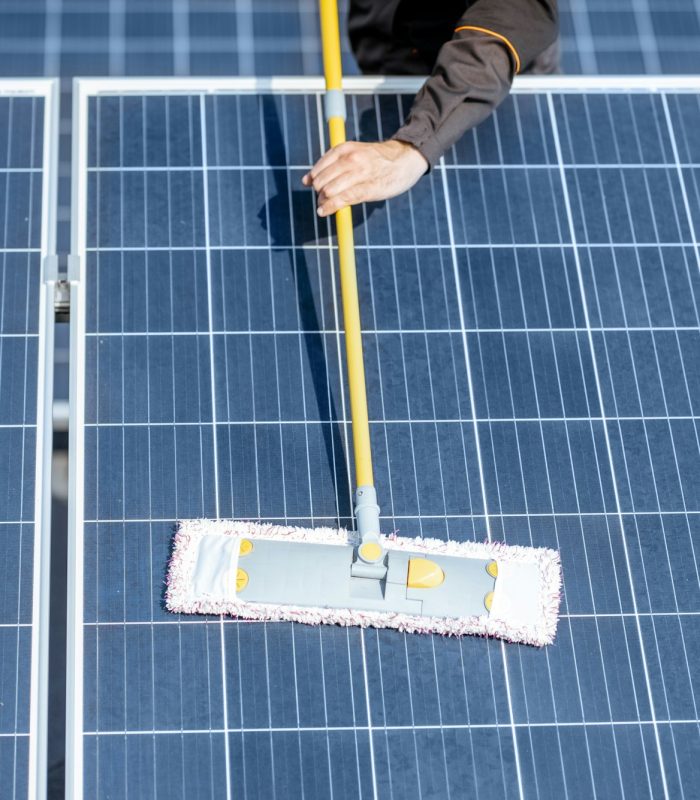 Workman cleaning solar panels